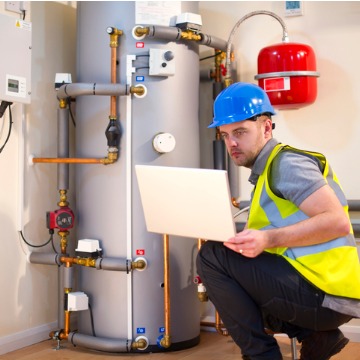 A technician checking a system with their computer during a Furnace Inspection in Peoria IL