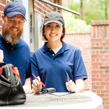 Repair people are outside of a home performing air conditioning Repair in East Peoria IL