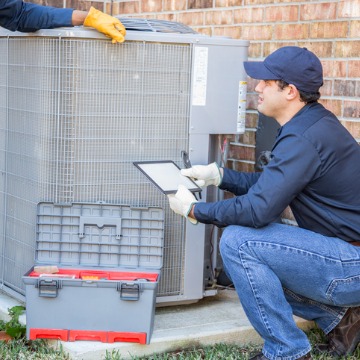 Team members from Chambers Services works to repair an air conditioner as an Air Conditioning Contractor in Bloomington IL