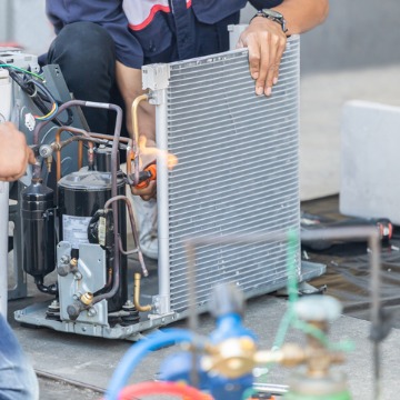 A man taking apart an air conditioning unit during AC Repair 