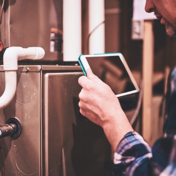 A technician inspecting a furnace during Heating Repair in Champaign IL