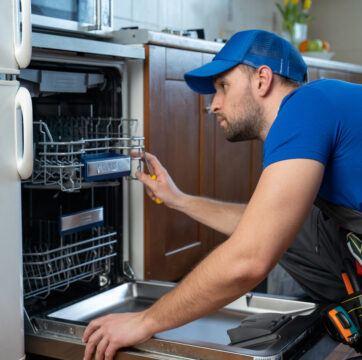 Man fixing a dishwasher, performing appliance repair in Central Illinois