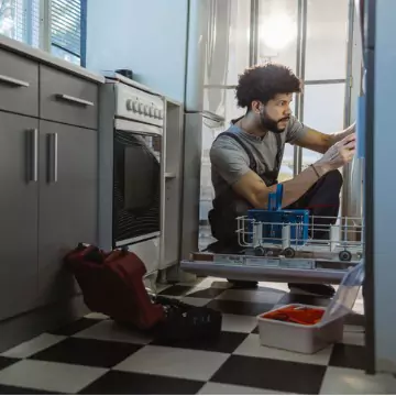 A team member from Chambers Services, who offers Dishwasher Repair in Peoria IL, works on a dishwasher