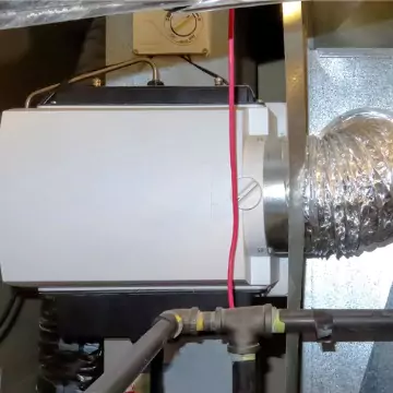 A home humidifier system attached to a duct system of a home in Peoria IL, helping improve Indoor Air Quality