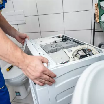 A Chambers technician removing the top panel of a washing machine to perform HVAC and appliance service in Springfield, IL
