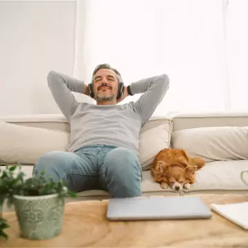 A man and his dog enjoying cool AC after receiving Heating and Cooling Services from Chambers Services