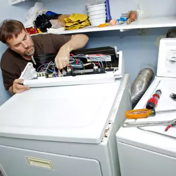 A technician diagnosing the problem with a dryer machine as part of Dryer Repair in Central Illinois