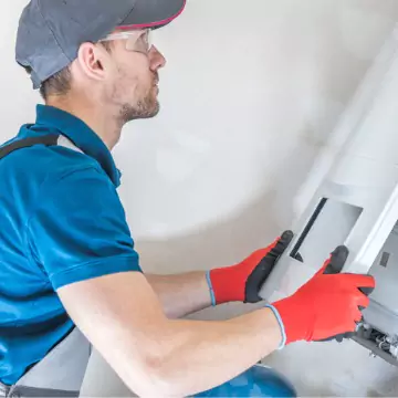 A technician replacing the panel on a new heating unit after Furnace Installation in Bloomington IL