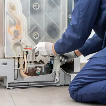 A Chambers technician performing dishwasher repair, as part of HVAC and appliance service in Decatur, IL