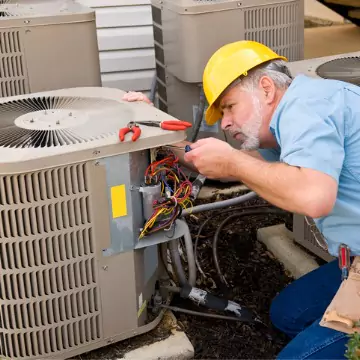 A Chambers technician hard at work on an outdoor air conditioning unit, performing AC Repair in Bloomington IL