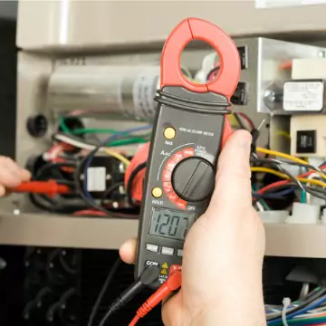 A Chambers tech checking the voltage of a heating system during standard Furnace Maintenance