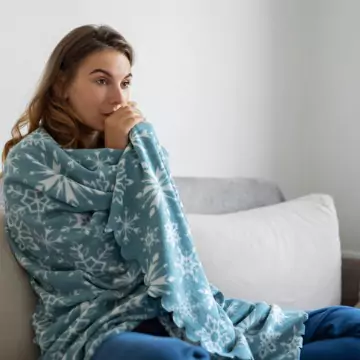 A young woman freezing at home, waiting for a technician to perform furnace repair in Dunlap IL