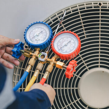 AC Repair Bloomington IL, Technician is checking air conditioner. Air conditioning, HVAC service technician using gauges to check refrigerant and add refrigerant
